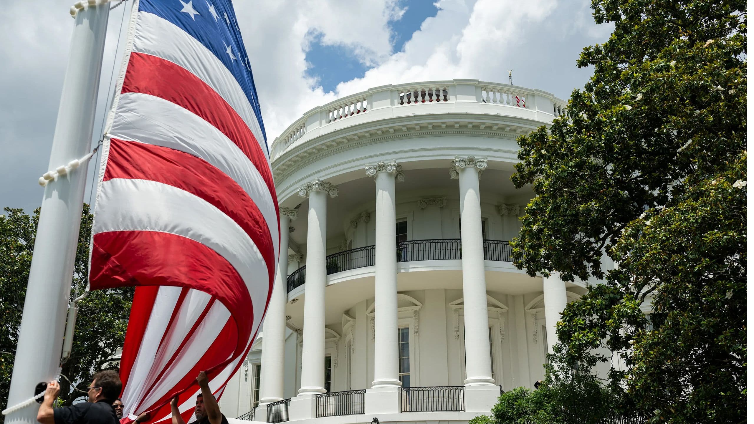 La Casa Blanca vista detrás de una gran bandera de Estados Unidos