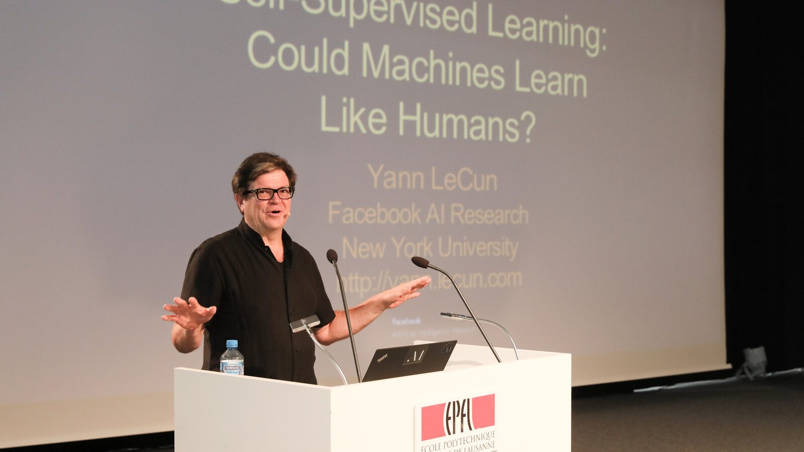 Yann LeCun giving a talk at EPFL in Lausanne in 2018, beside a slide asking whether machines could learn like humans