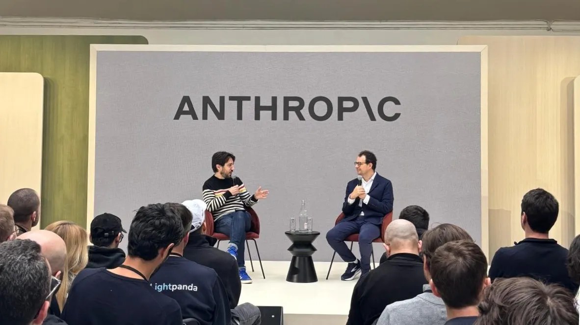 Charla en un escenario con el logotipo de Anthropic al fondo