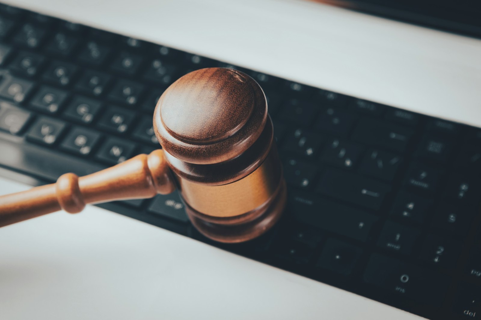 Judge's gavel resting on a laptop keyboard