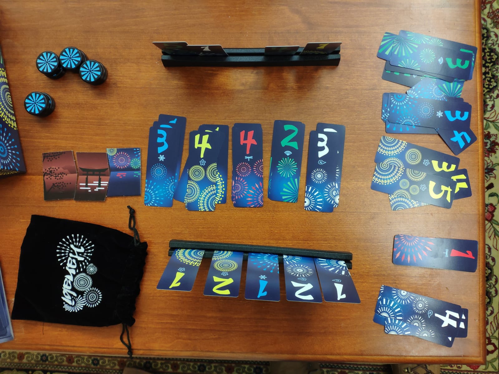 Numbered cards in several colors and tokens from Hanabi, in an illustrative photograph unrelated to the Ataraxos tests