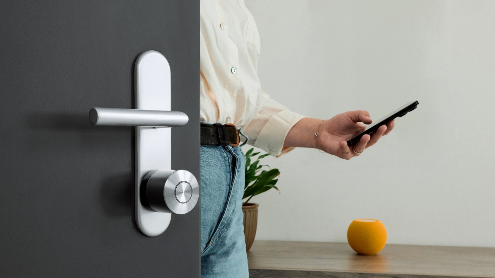 Nuki smart lock installed on a door while a person uses a phone