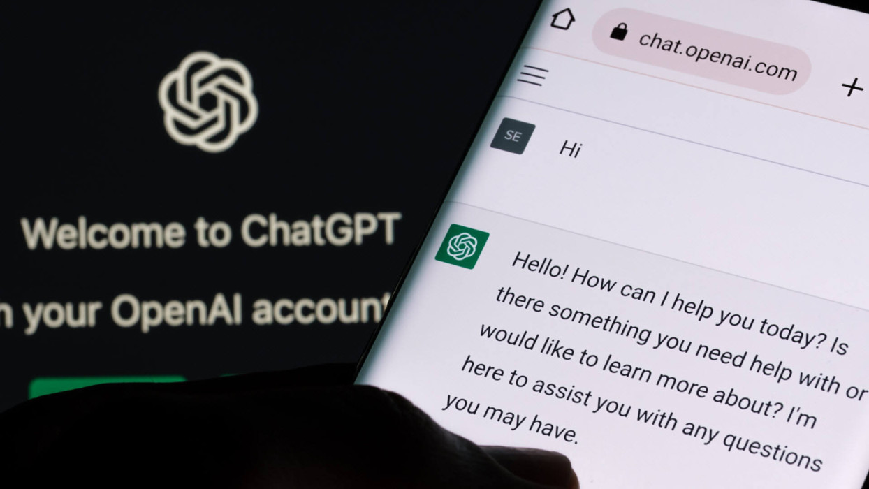 ChatGPT abierto en un teléfono frente a la pantalla de inicio de OpenAI