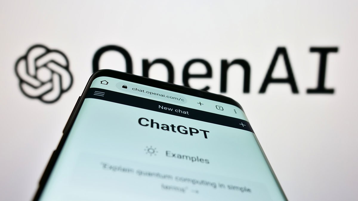 A phone with ChatGPT open in front of the OpenAI logo