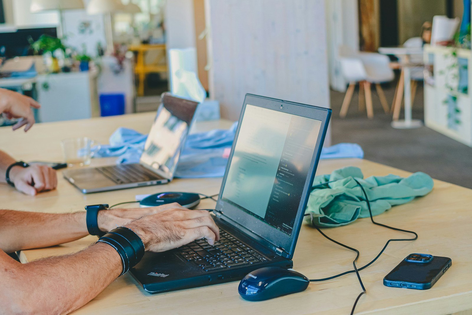 Several people work with laptops at a shared table