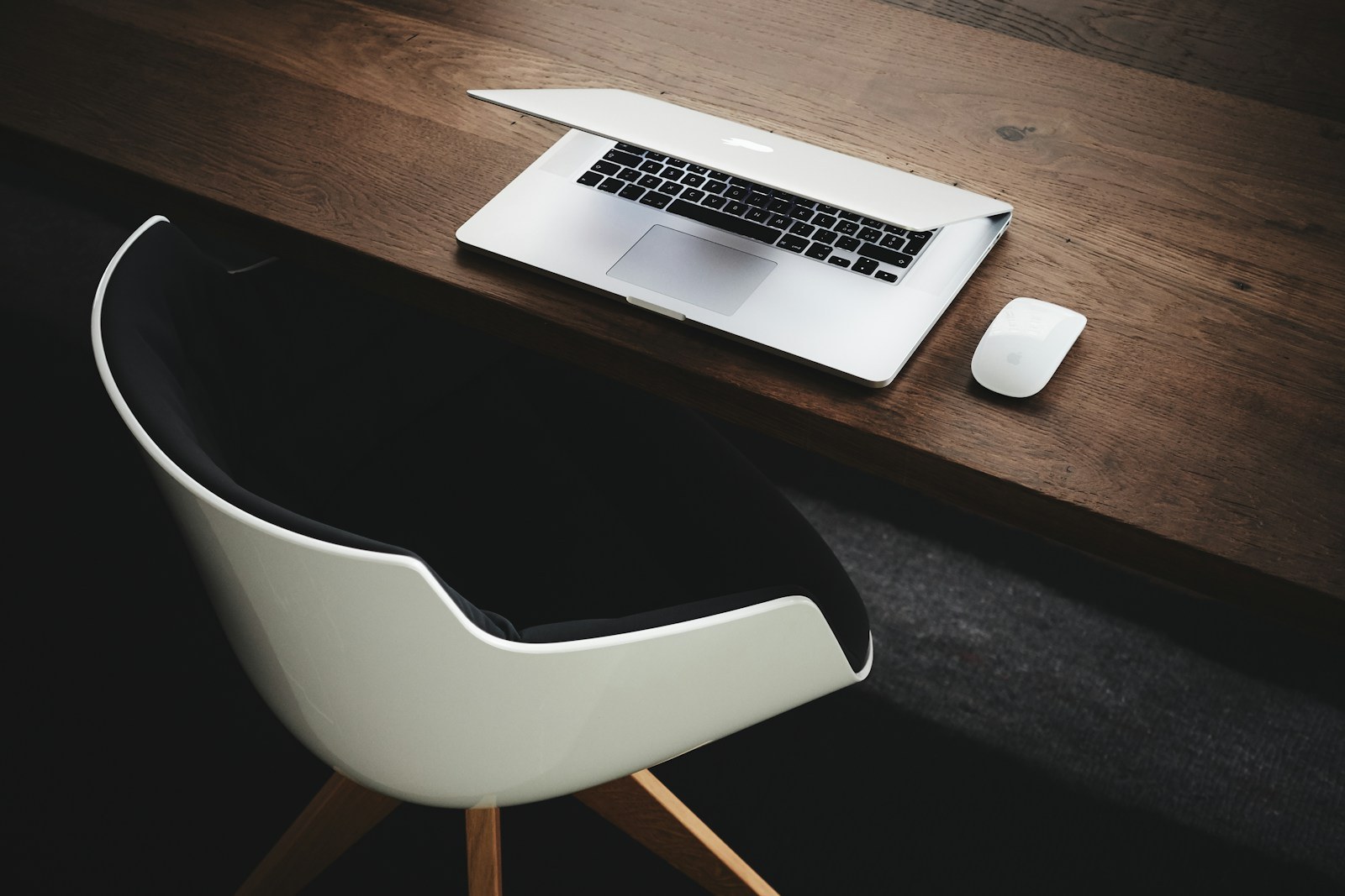 A partly closed laptop on an empty desk, illustrative photograph