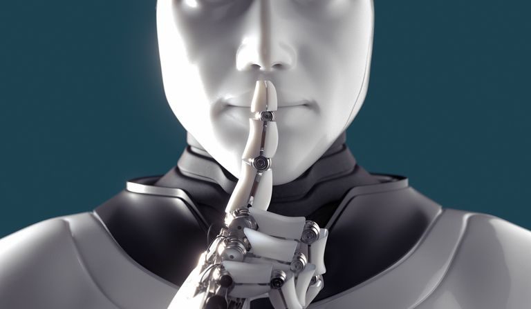 A white humanoid robot raises a finger to its lips asking for silence