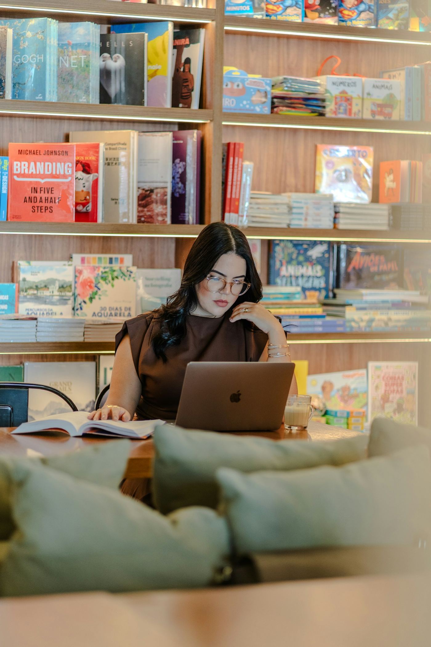 Persona trabajando con un portátil y libros, fotografía de contexto