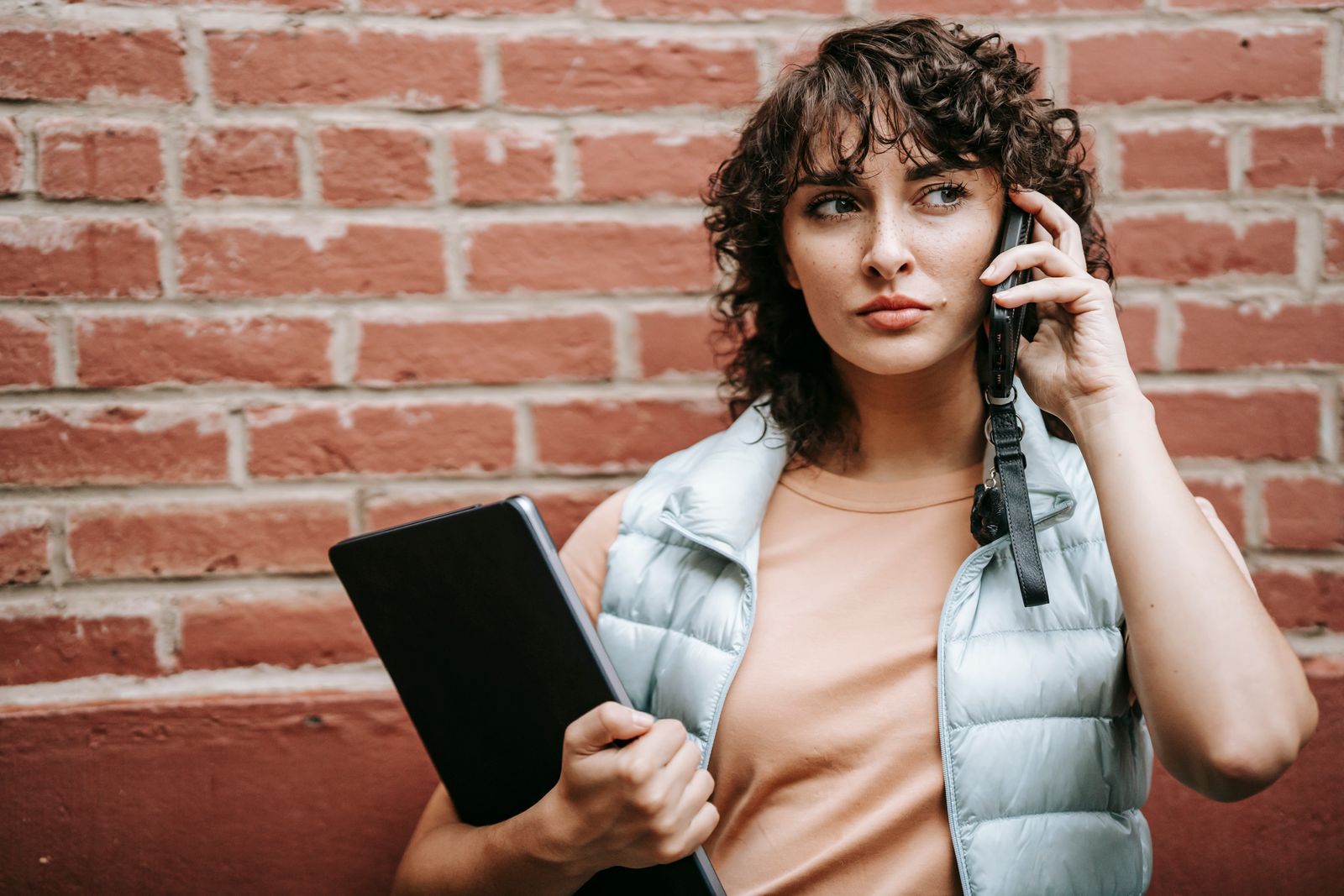 Persona con un portátil hablando por teléfono, fotografía de recurso