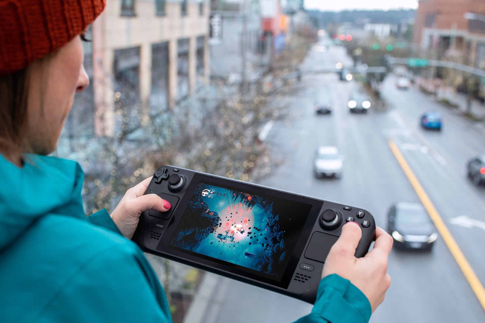 Una persona juega a Hollow Knight en Steam Deck frente a una ventana