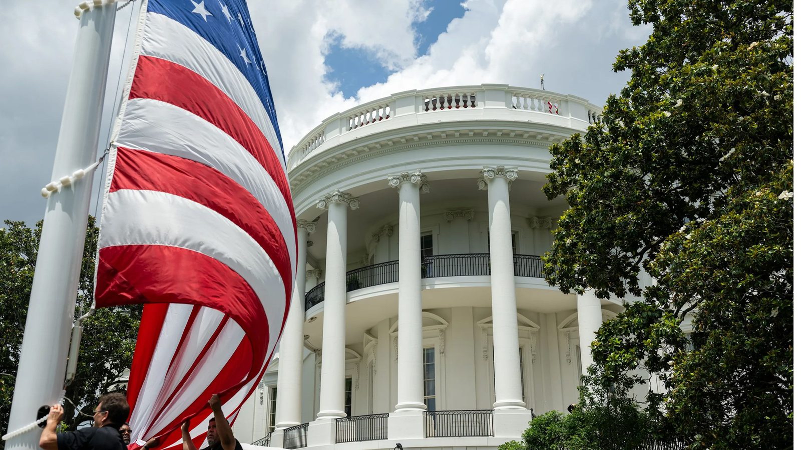 The White House seen behind a large United States flag