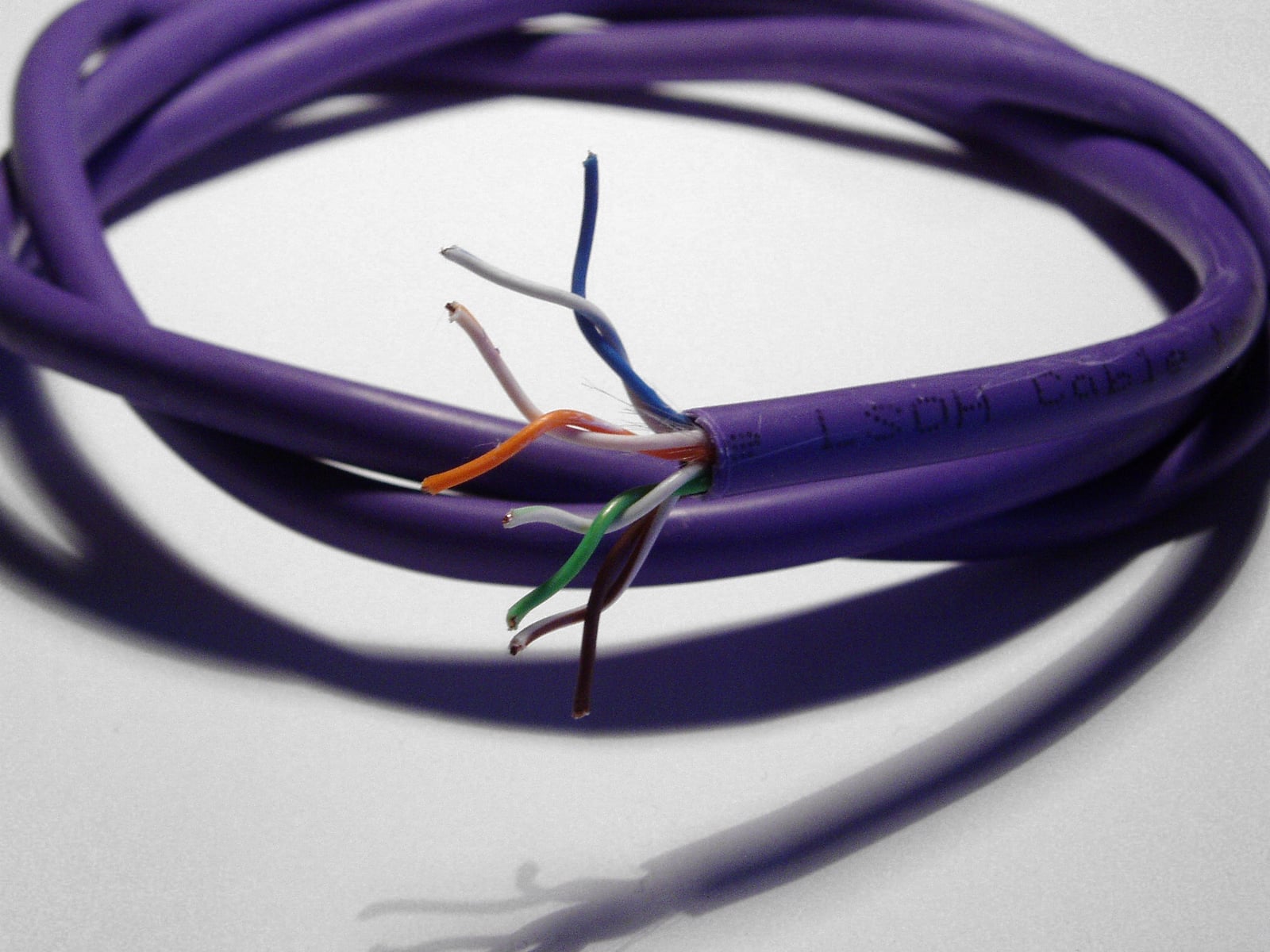 Cable Cat 5e abierto para mostrar sus cuatro pares de hilos azules, naranjas, verdes y marrones