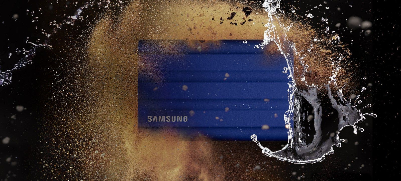 Blue Samsung T7 Shield SSD in a promotional photograph with water and dust