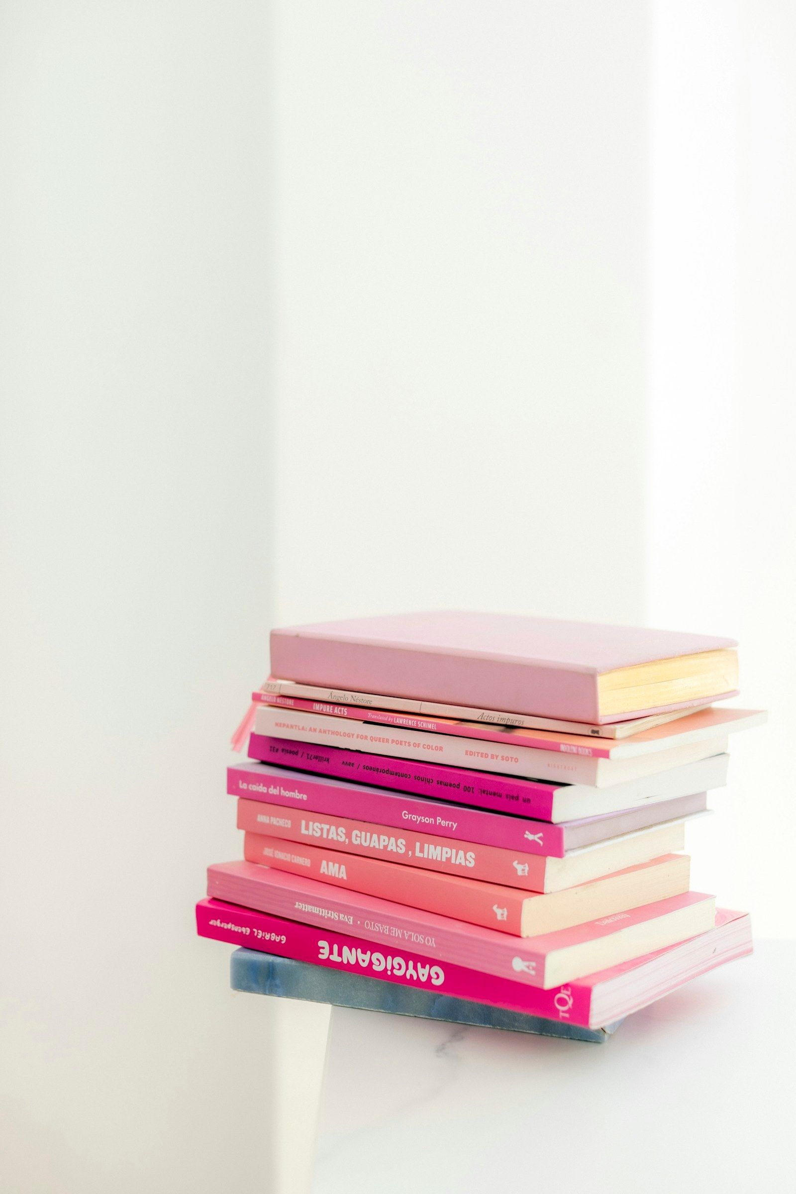 Pila de libros rosas sobre una mesa clara
