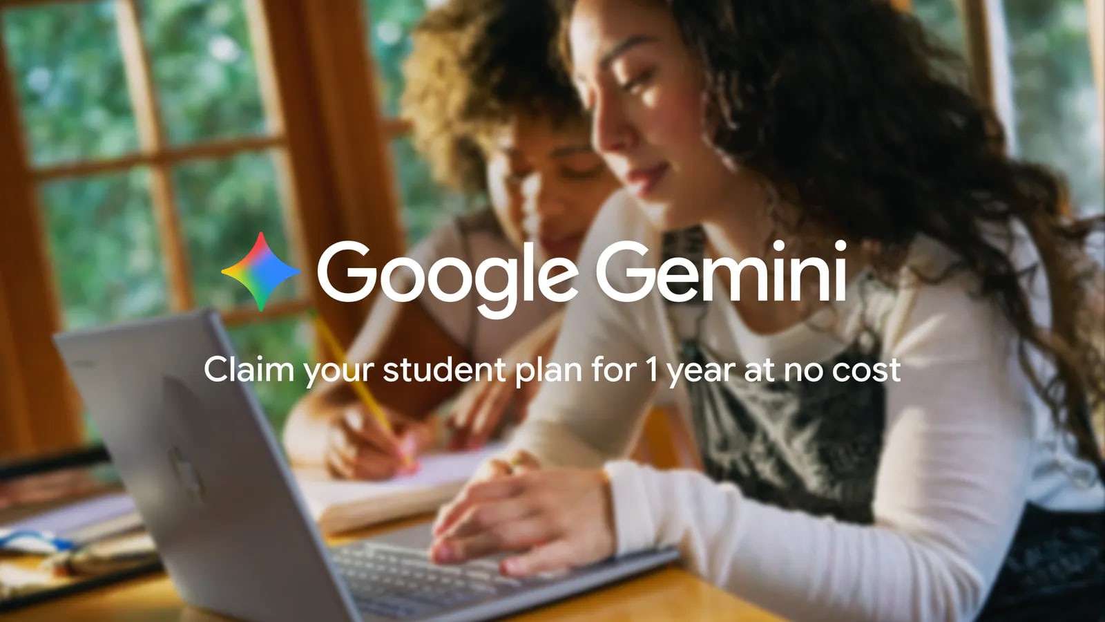 Dos estudiantes trabajan con un portátil bajo el anuncio oficial de un año de Google Gemini sin coste