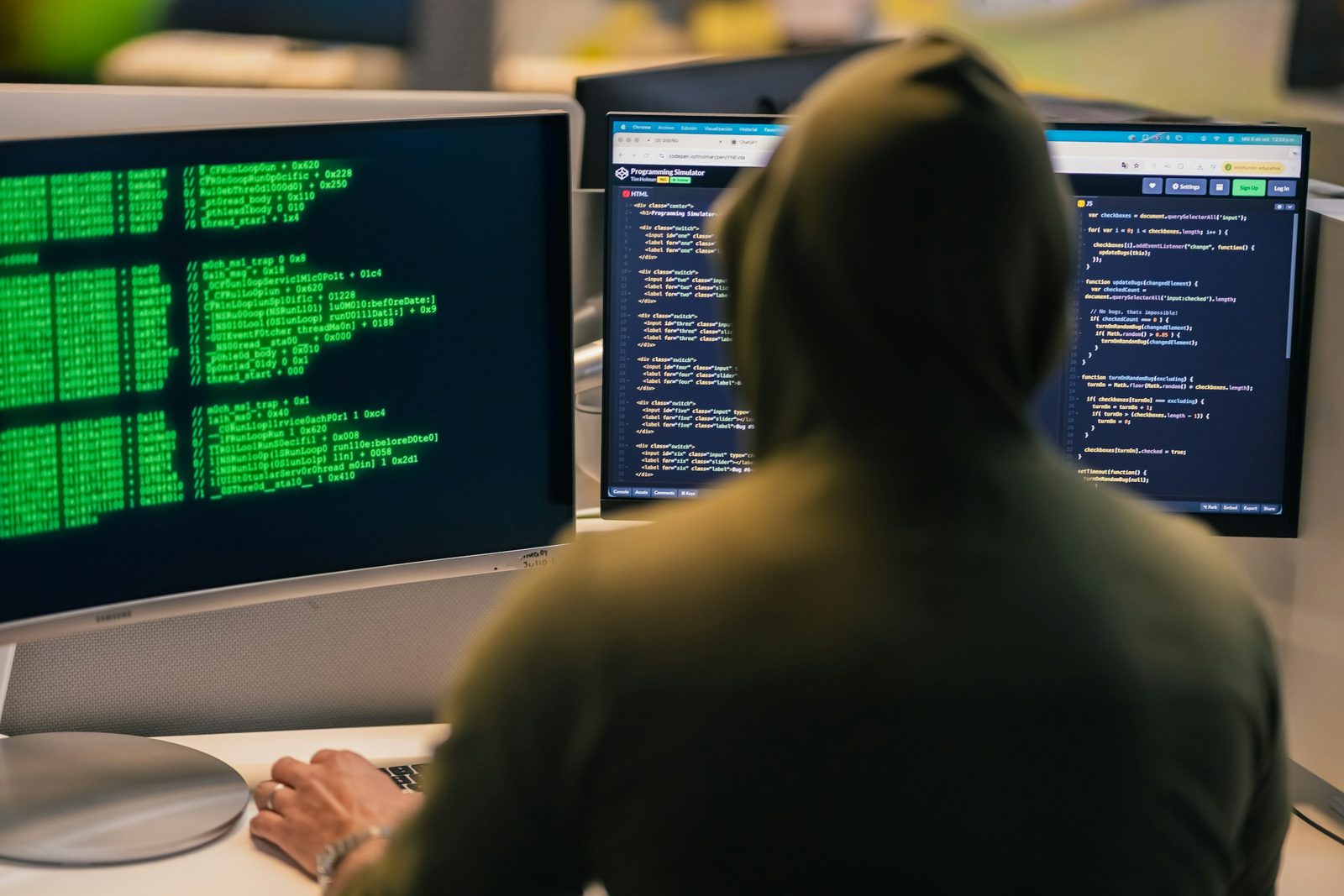 Cybersecurity researcher working in front of several screens displaying code