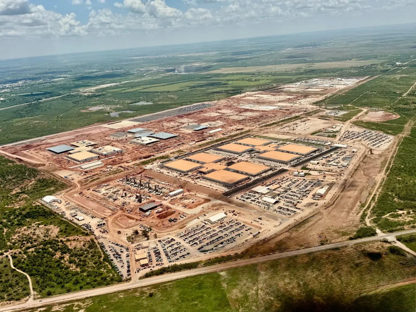 Large technology complex under construction seen from the air, with several buildings and active work zones