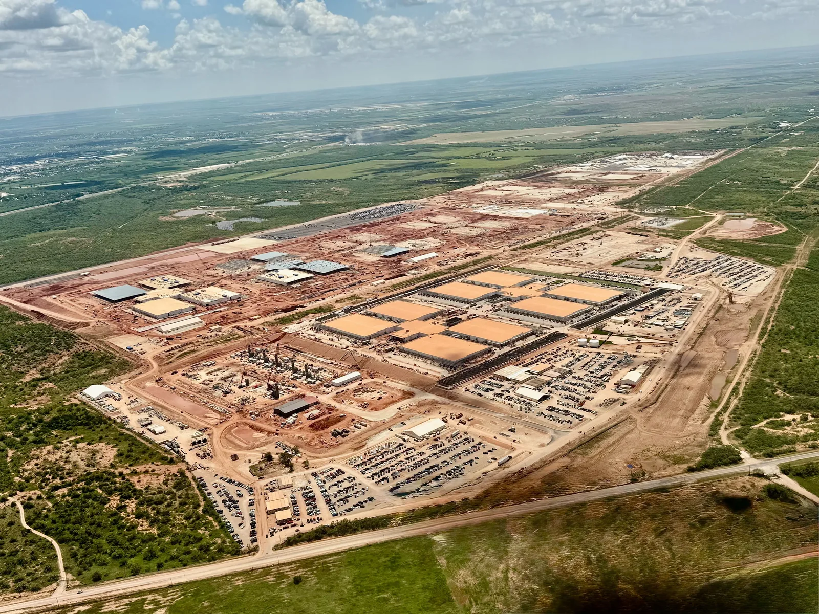 Large technology complex under construction seen from the air, with several buildings and active work zones