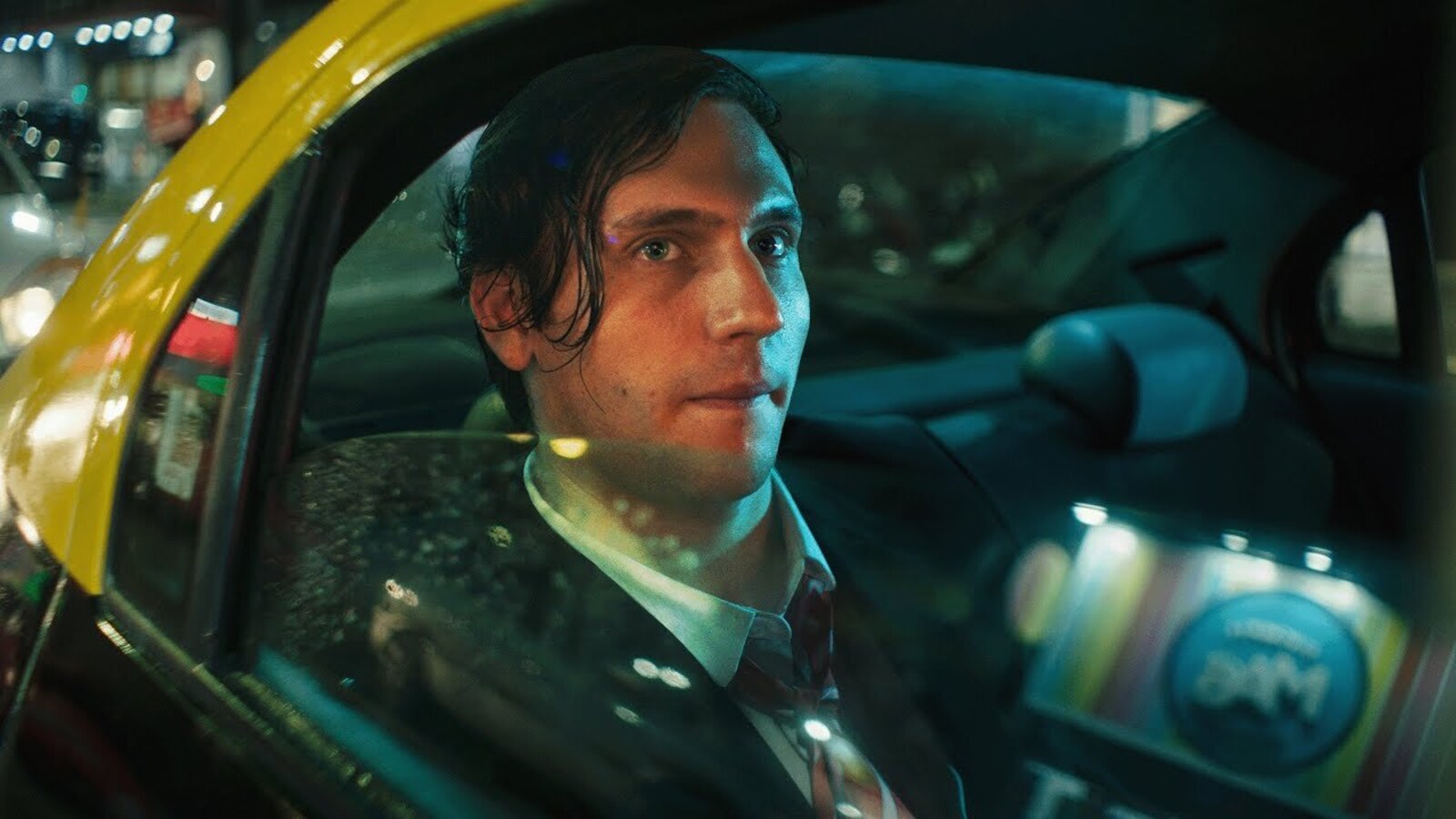 Gaspi, in a suit and tie, looking out of a taxi window at night in Buenos Aires in the video announcing his return to YouTube