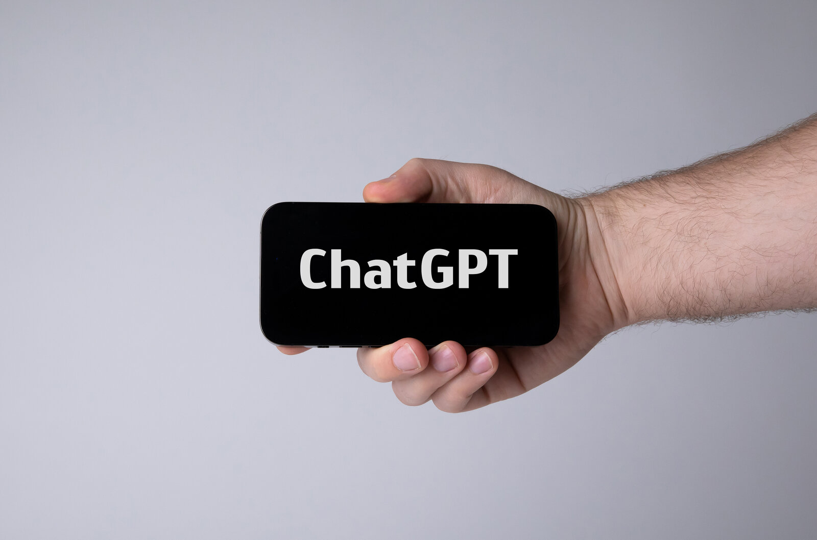Mano que sostiene un teléfono móvil con ChatGPT abierto en la pantalla