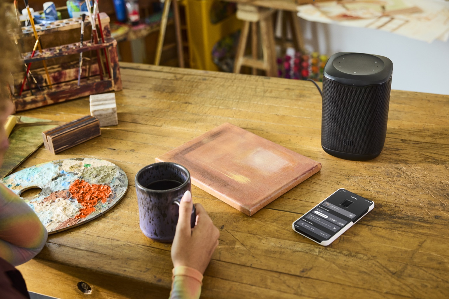 JBL Cove M1 sobre una mesa de trabajo junto a la aplicación JBL One