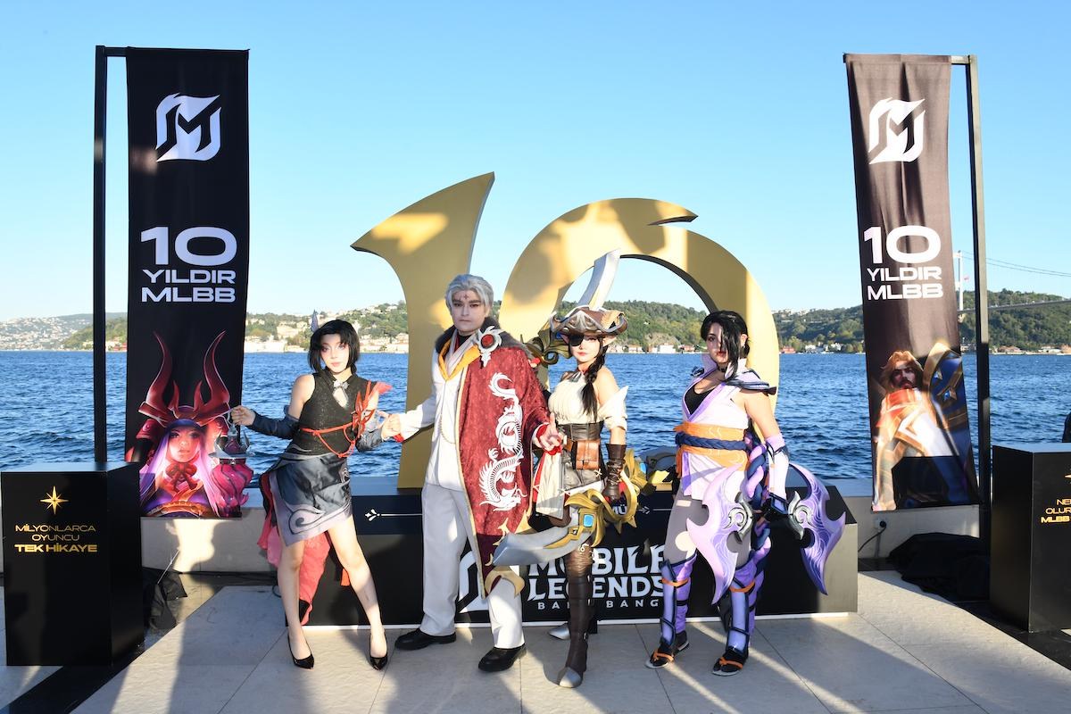 Cosplayers next to a giant golden number 10 at the Mobile Legends 10th anniversary celebration on the Bosphorus in Istanbul