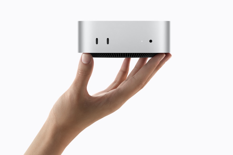M6 Mac mini on a desk beside a monitor