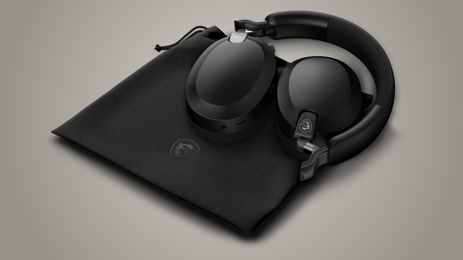 The black MSI Maestro 500 Wireless folded with the earcups turned inward, resting on its black fabric pouch with the MSI shield