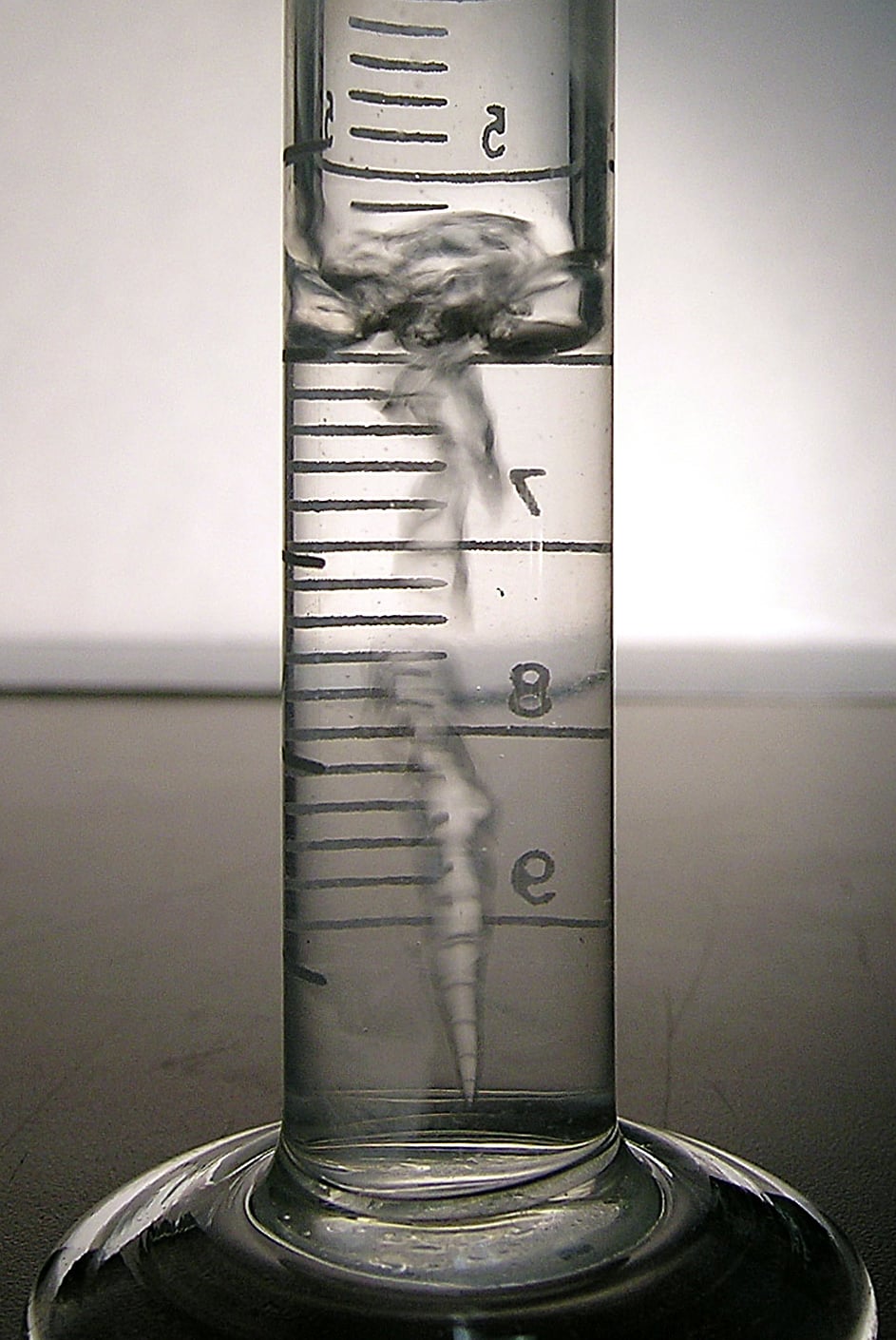 Líquido hirviendo dentro de una probeta graduada en un experimento de laboratorio