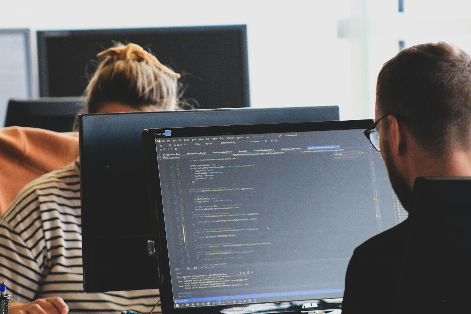 Dos personas trabajando con código en una oficina, fotografía de contexto y no una prueba de los modelos