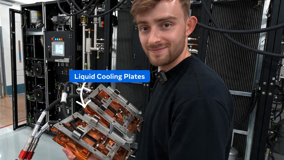 Tom Shaw holds liquid-cooling plates in front of a rack
