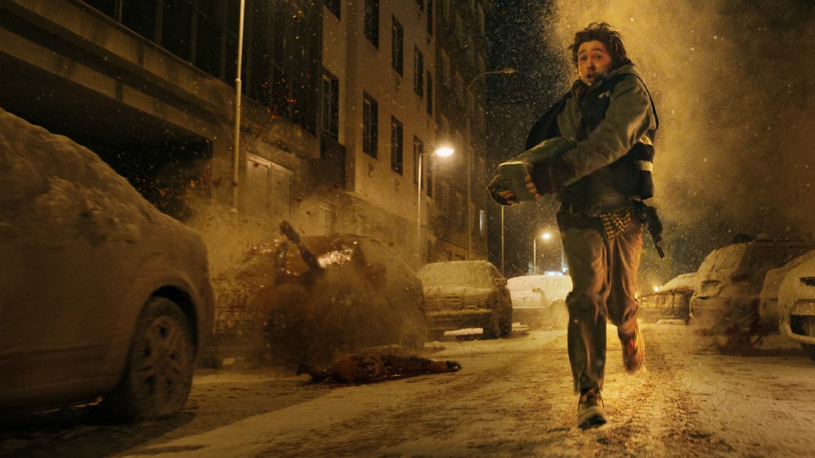 Bryan runs with a medical package between snow-covered cars in Resident Evil