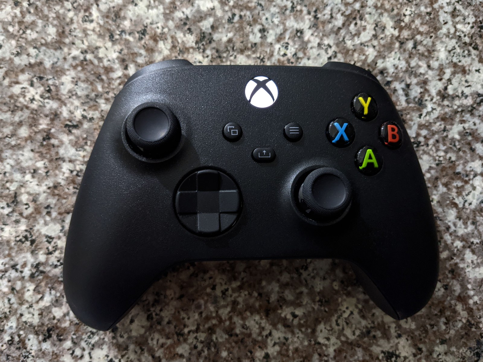 A Carbon Black Xbox Series wireless controller resting on a light surface