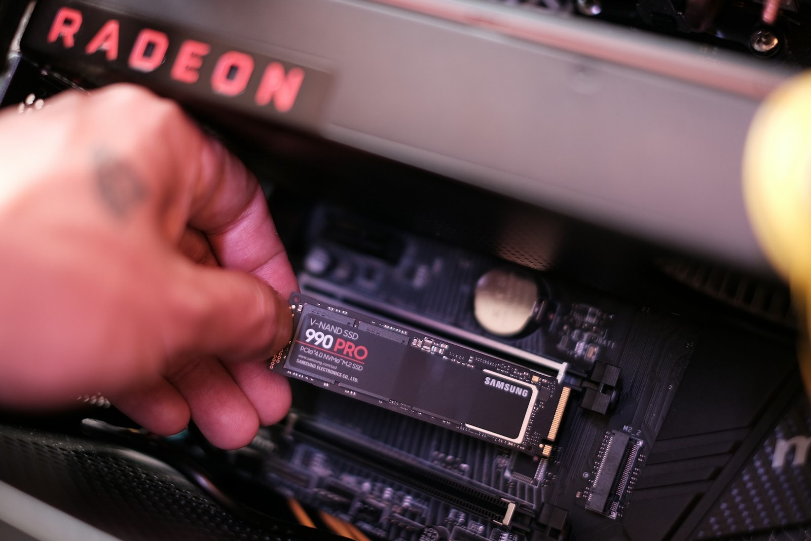 Una mano instala un SSD M.2 en una placa base