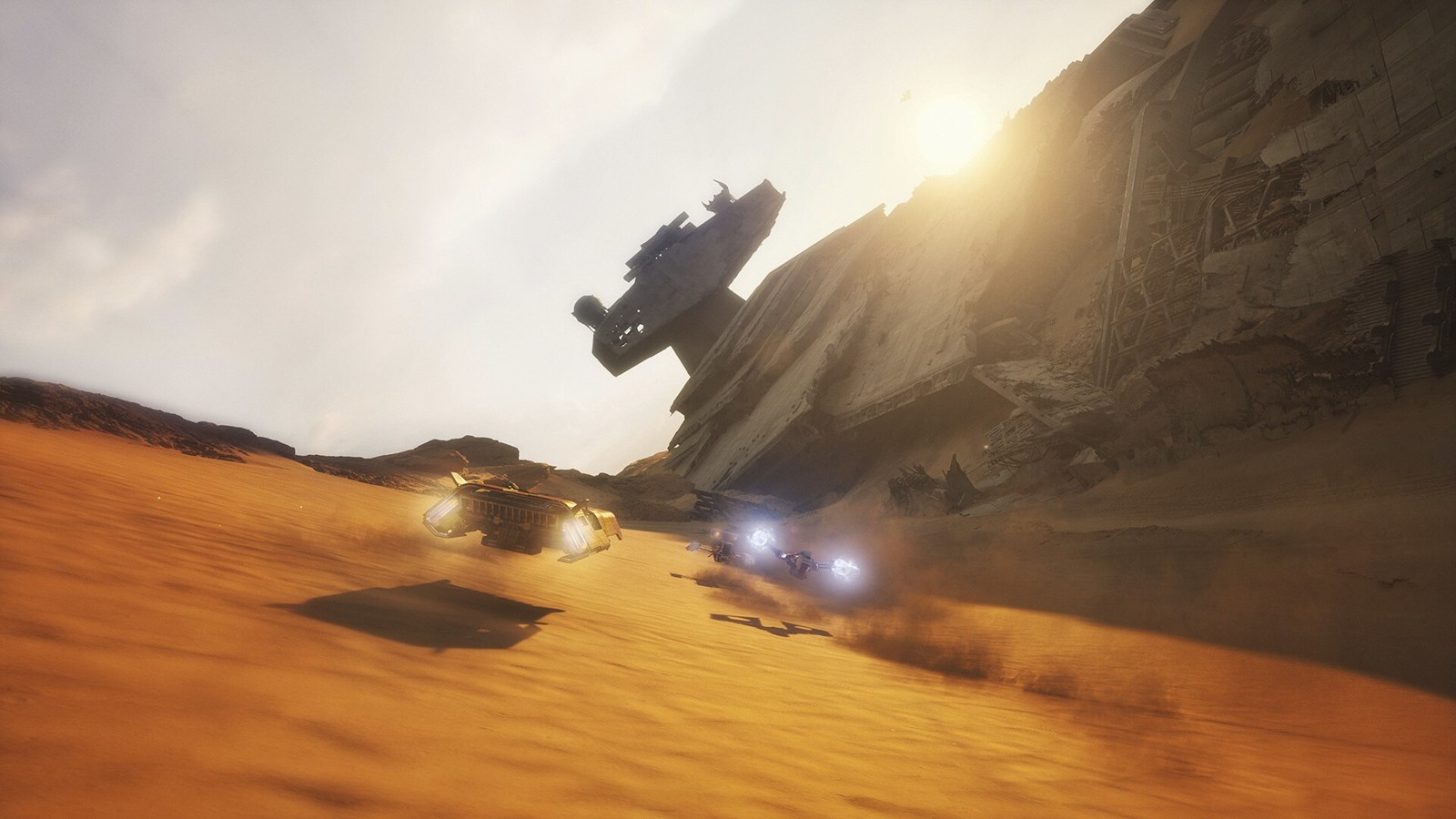 A racing vehicle passes Star Destroyer wreckage on Jakku
