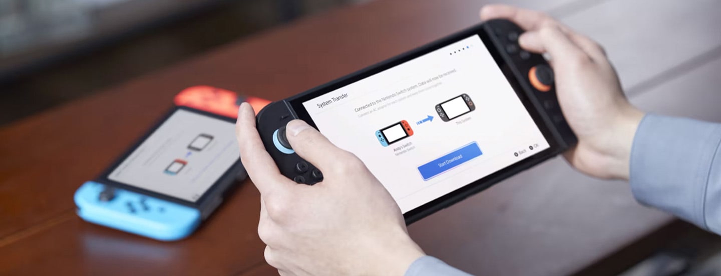 A person starts a system transfer on Nintendo Switch 2 with the original Nintendo Switch behind it