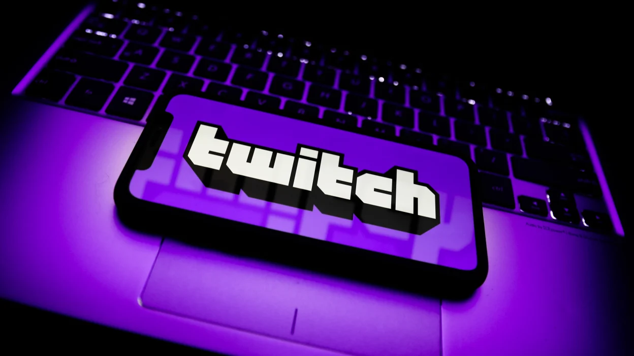 Logotipo de Twitch abierto en un teléfono sobre el teclado de un ordenador